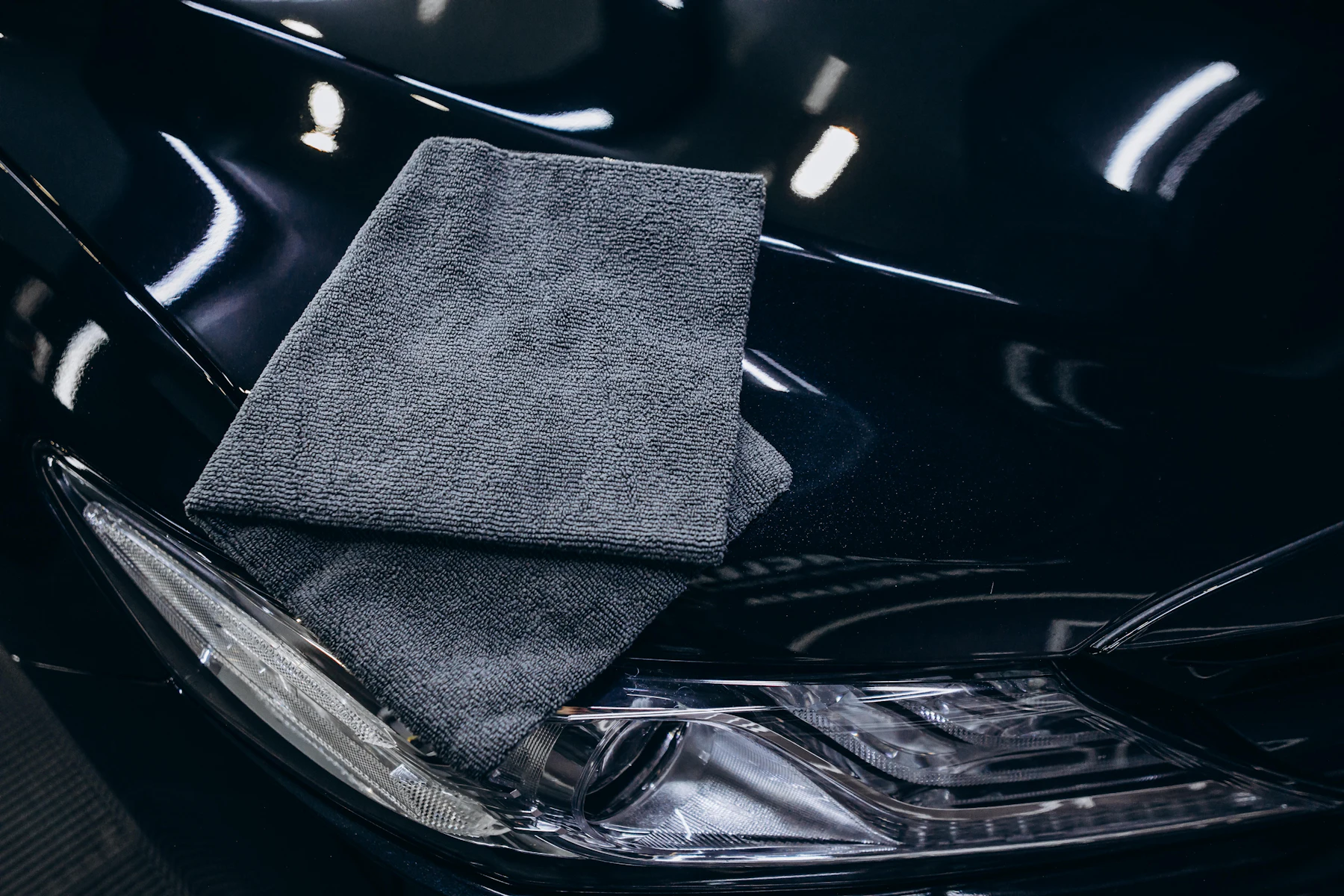 Microfiber towel resting on a glossy black car