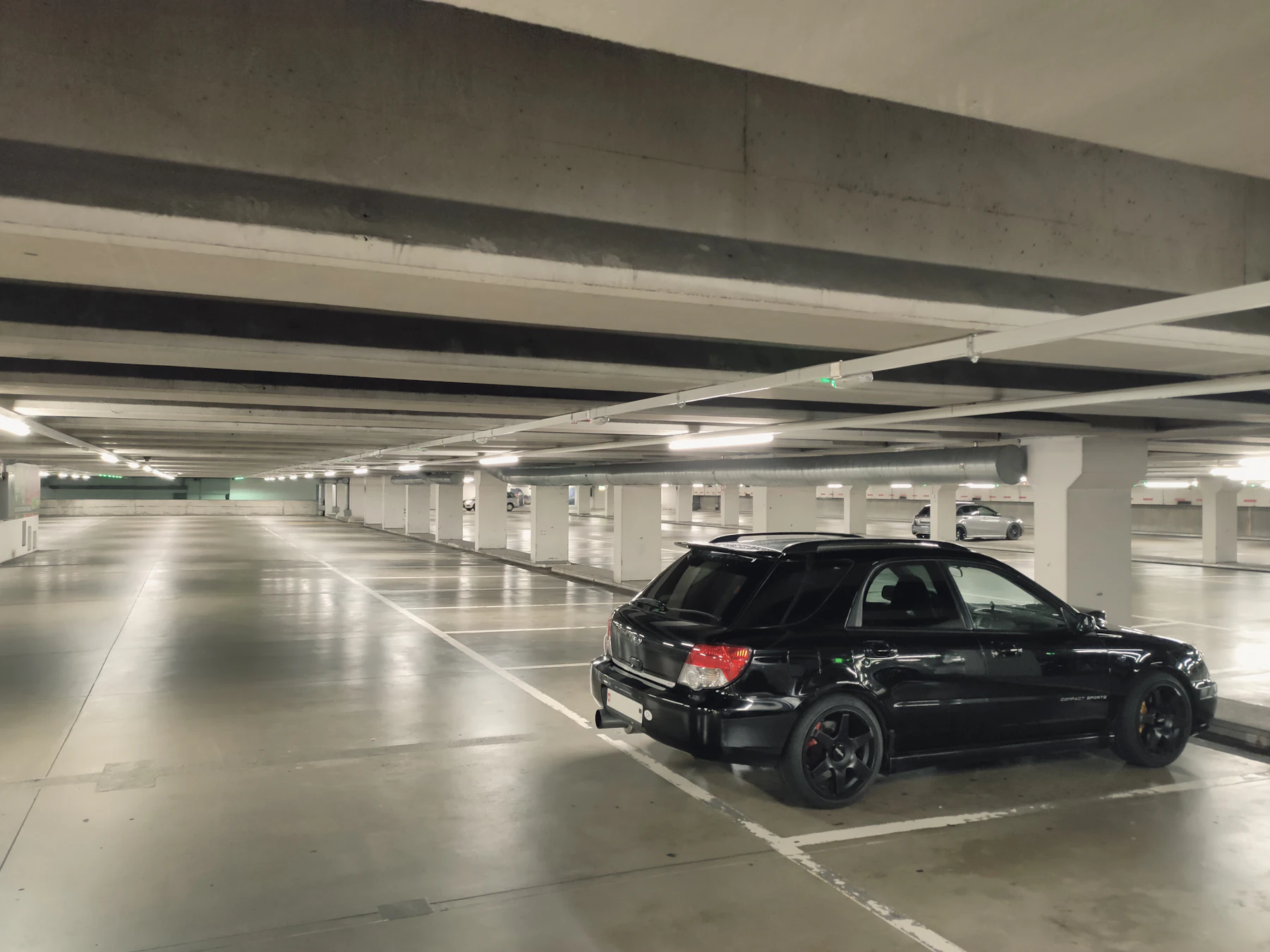 Black car parked in a bright residential car park